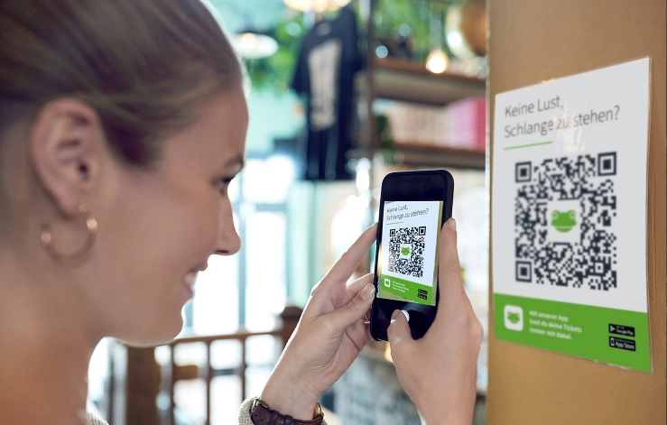 Frau scannt QR-Code von Eventfrog