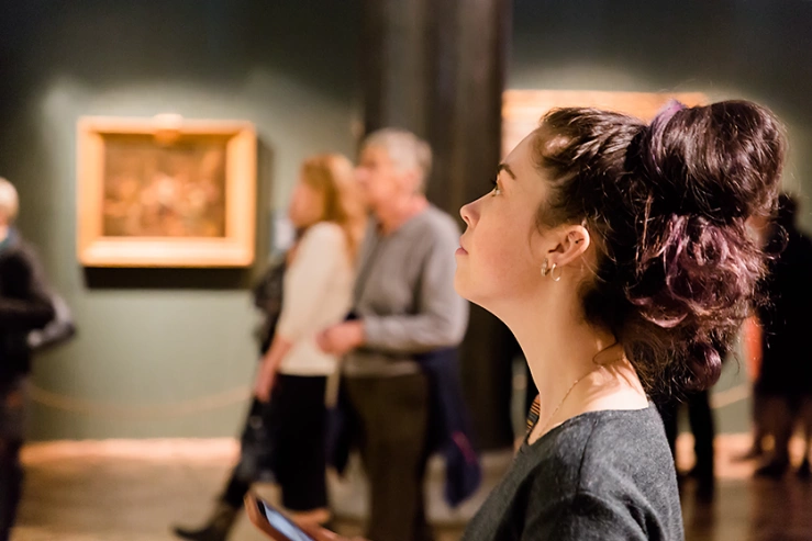 Frau schaut auf Gemälde im Kunstmusuem